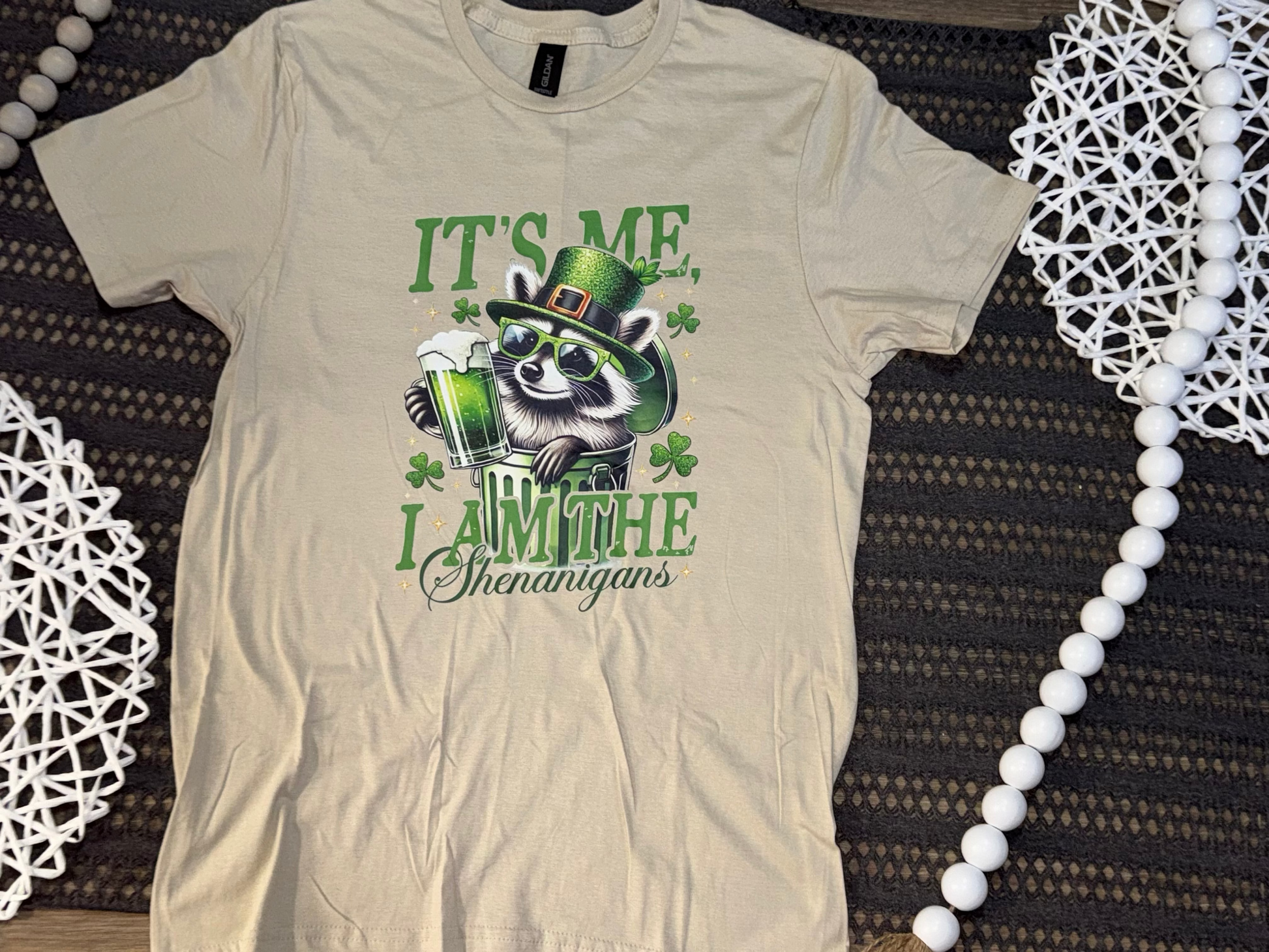 Beige tank top with green graphic design on a textured surface